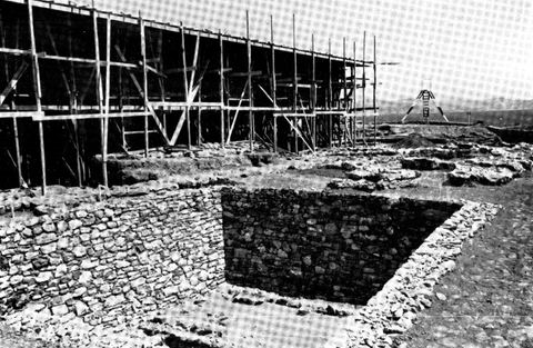 Lerna: a Neolithic house in the foreground and, at left behind, the shelter for the House of the Tiles under construction with wooden scaffolding.