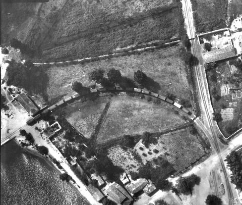 Crop of the 1941 aerial photo: a goods train of about 25 wagons on the curved siding from the main line to the pier, a level crossing, village houses and the start of the pier.