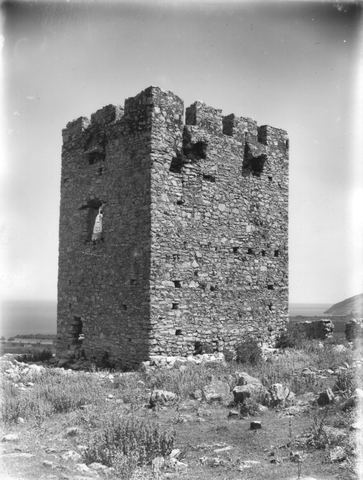 Glass-negative photograph of the Tower of the Vasilopoula (Pyrgos Vasilopoulas) between Myloi and Kiveri, crenellated and still fairly intact, with the sea and a cape at right.