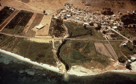 Oblique aerial view of Lerna and Myloi from the east: the excavation with the House of Tiles shelter, the village, railway and road, the spring stream reaching the sea, beach and orchards.