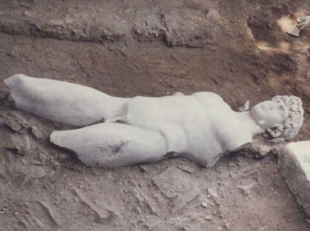 The marble statue of Antinoos lying in the excavation trench near Myloi, 1986