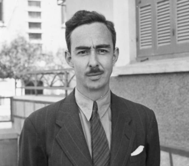 Black-and-white portrait of John L. Caskey in a pinstripe suit and tie
