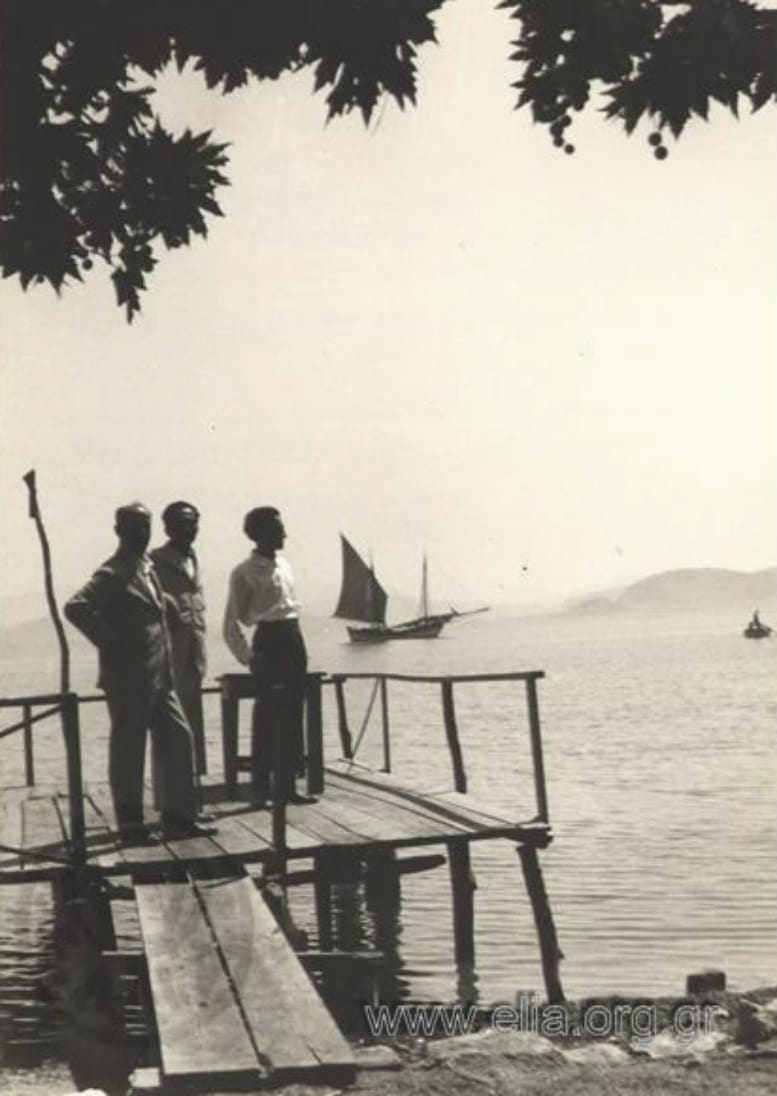 Nikos Kazantzakis and two friends standing on the wooden jetty at Myloi in 1927