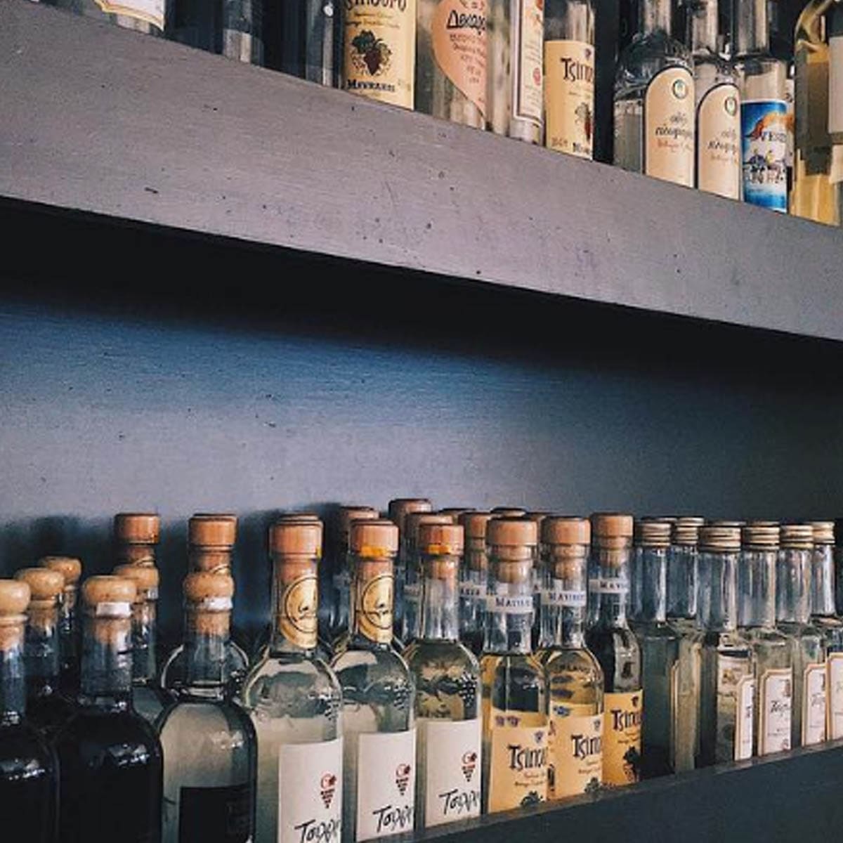 Shelves lined with bottles of ouzo and tsipouro