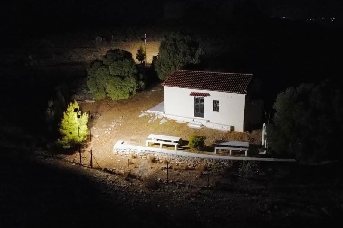 The white chapel of Profitis Ilias on Pontinos hill, lit up at night