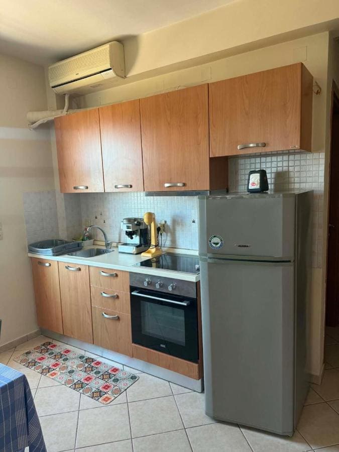 Kitchen with wooden cabinets, an oven, a fridge-freezer and air conditioning
