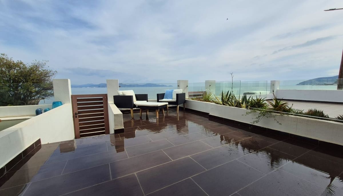 Sea-view terrace of Blue Bay Suites with armchairs and a view over the bay