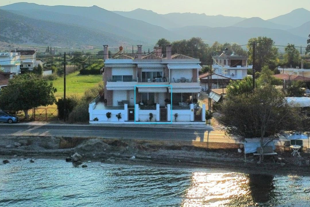 Drone view of the house with Blue Bay Suites on the coast road, with the bay in front
