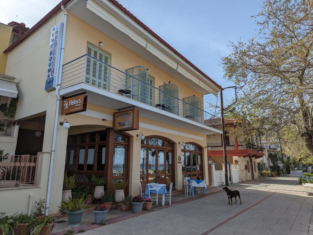 The cream-coloured Helen's Rooms building on the waterfront street, with balconies above arched taverna windows