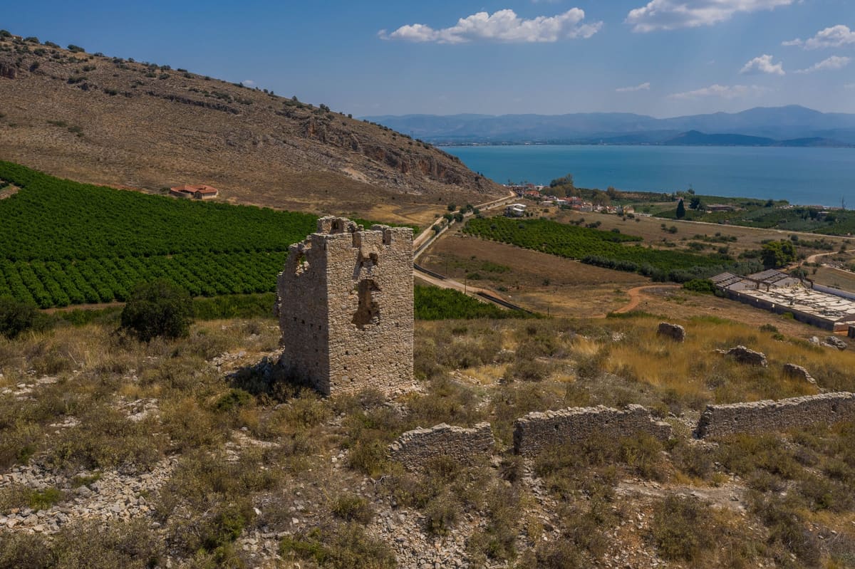 The tower and the remains of its enclosure wall, with the sea behind